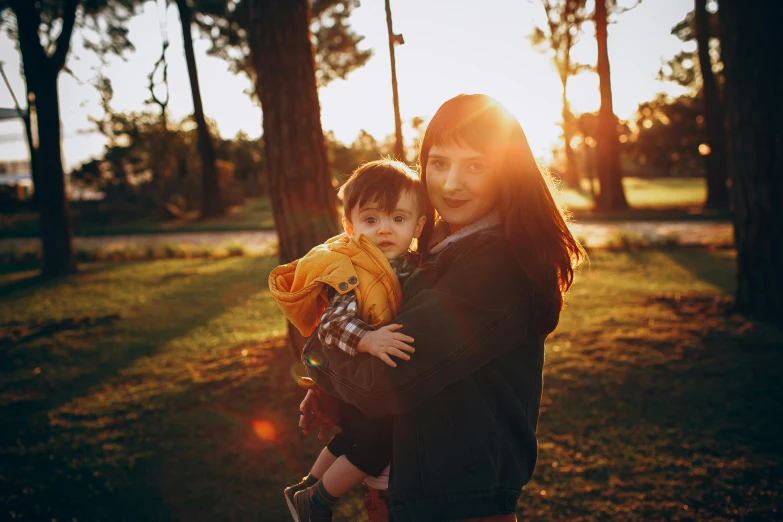 a woman holding her child in the park