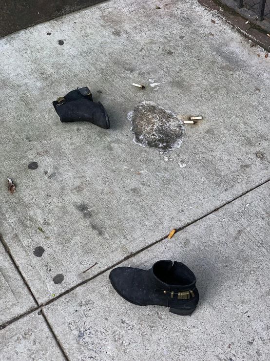 a pair of shoes sits on the sidewalk