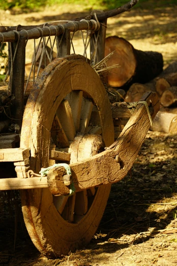 a log wagon with large wheels is in the shade