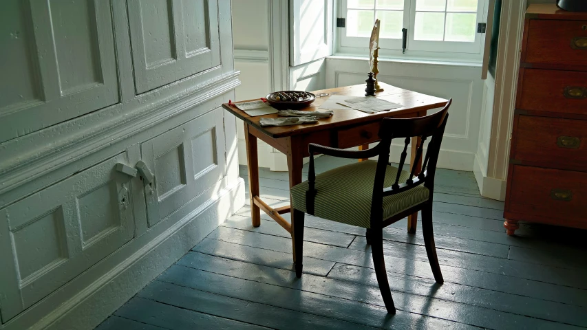 the corner of a room with a table and chairs