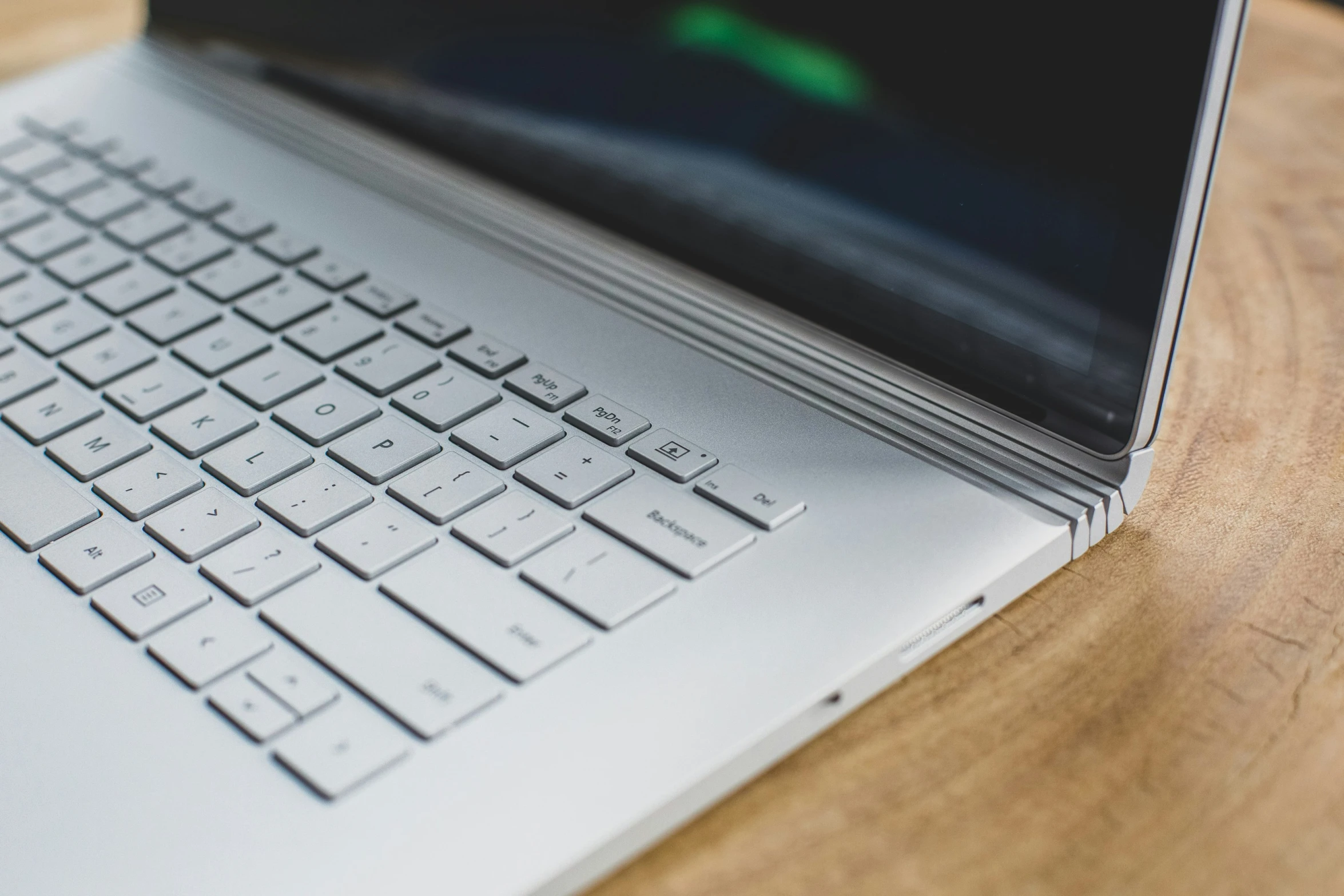 close up of an apple laptop on a wood table