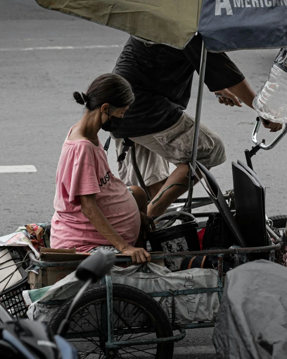 a man sits on his motorcycle with an umbrella over it