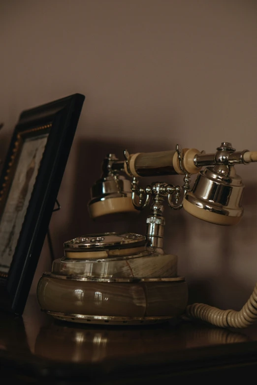 old style telephone is sitting on top of a wooden shelf