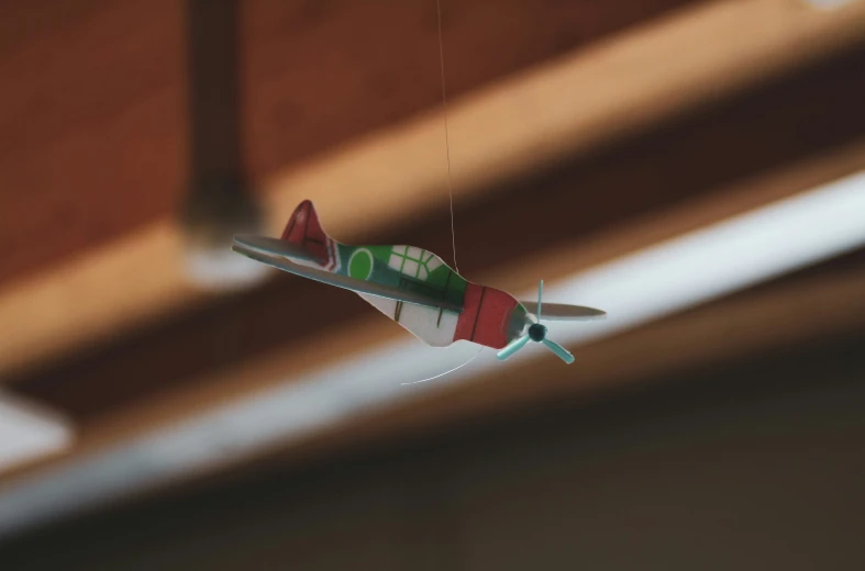 a red and green airplane hanging from the ceiling