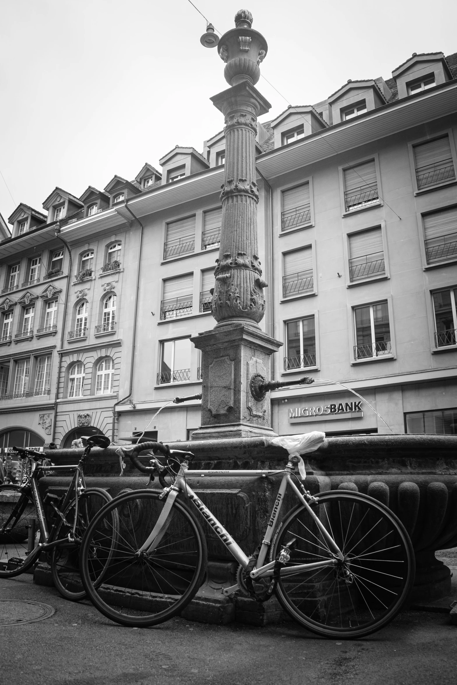 three bikes are parked next to a tall building