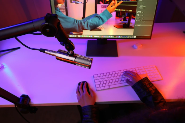 a person sitting in front of a computer monitor with an electronic device