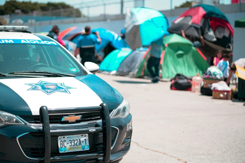 police car sitting in front of tents outside