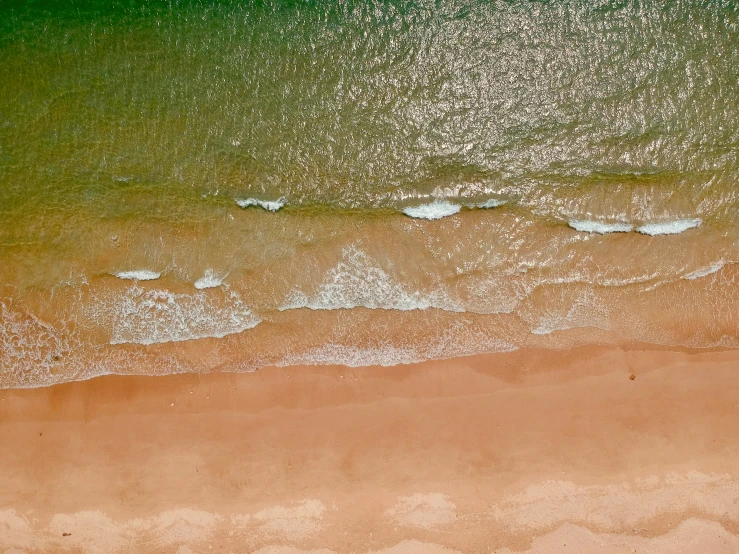 an aerial view of beach and water in the distance