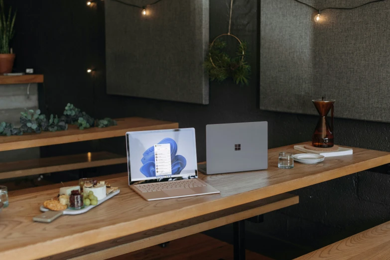 a wooden desk with a lap top and drink