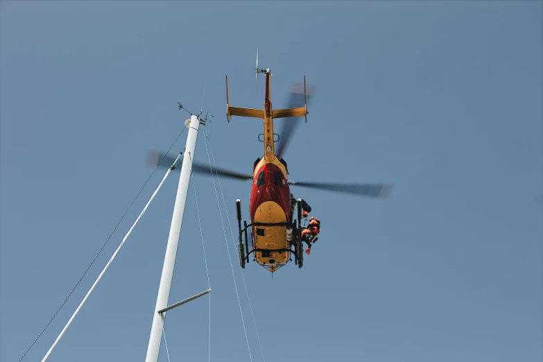 helicopter flying upside down while pulling a man off his rig