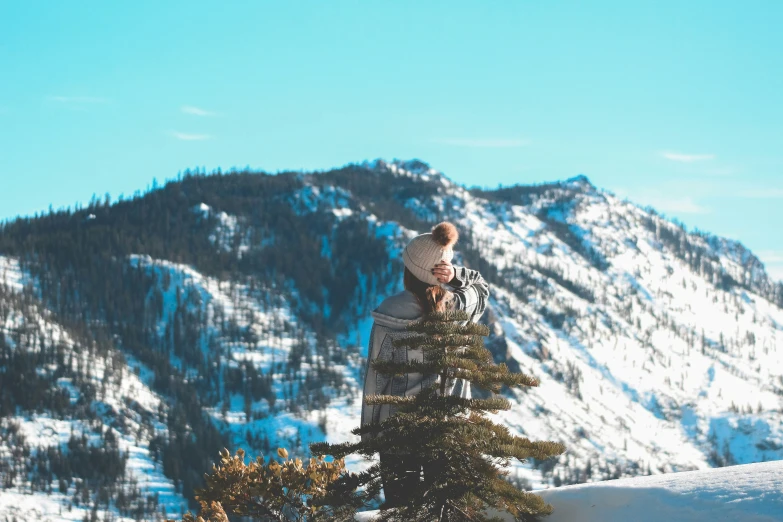 man stands on top of a tree in the snow