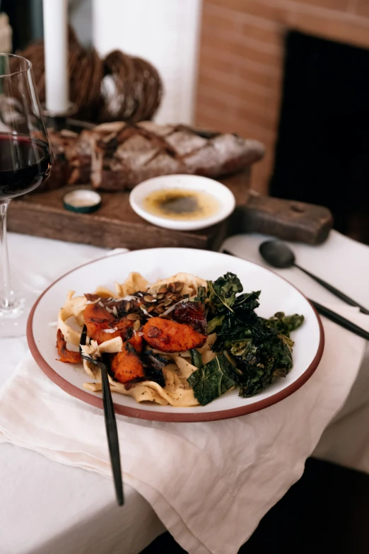 a plate of food with a glass of wine next to it