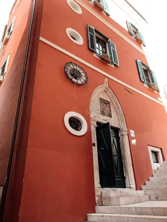 a red building with two clocks above the door