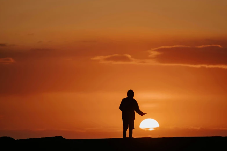 a person holding up the sun in the background