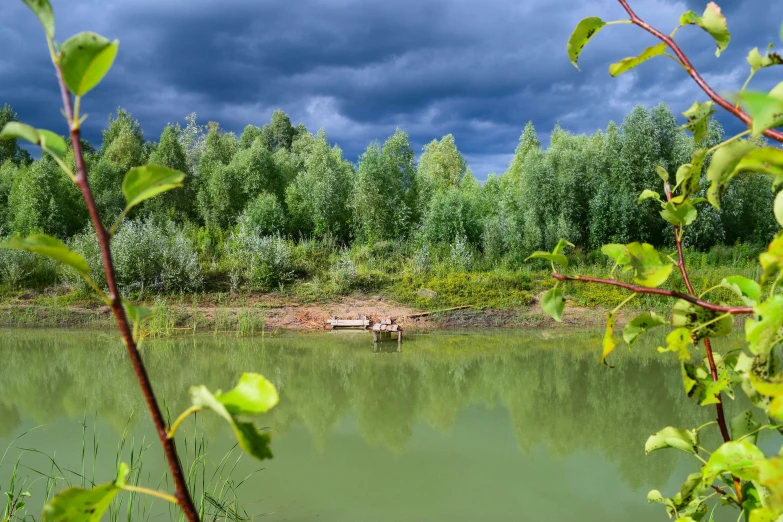 a body of water sitting under a cloudy sky