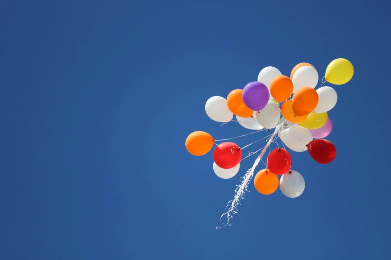 an assortment of balloons floating in the air