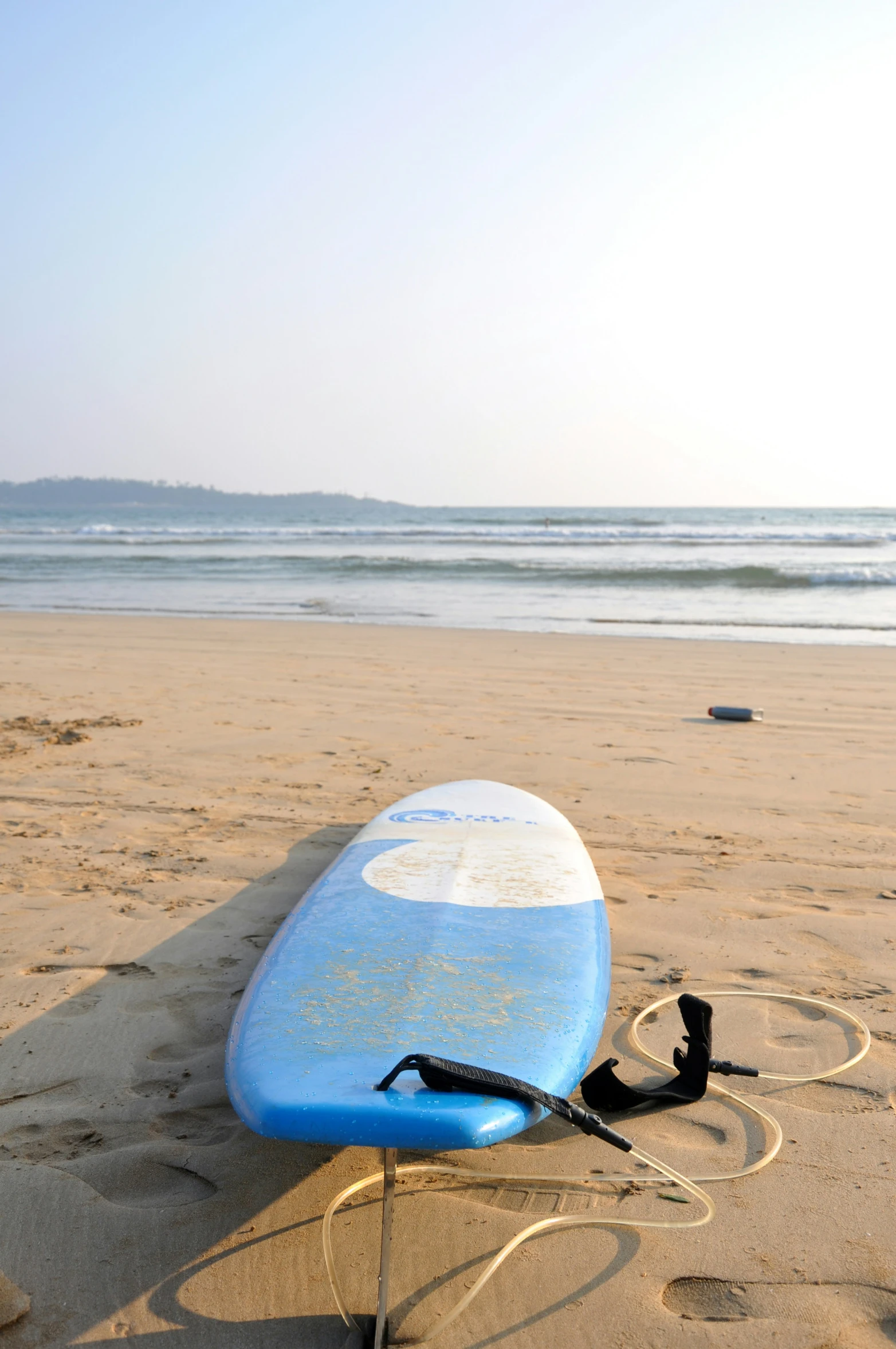 a surfboard resting on the sand at the beach