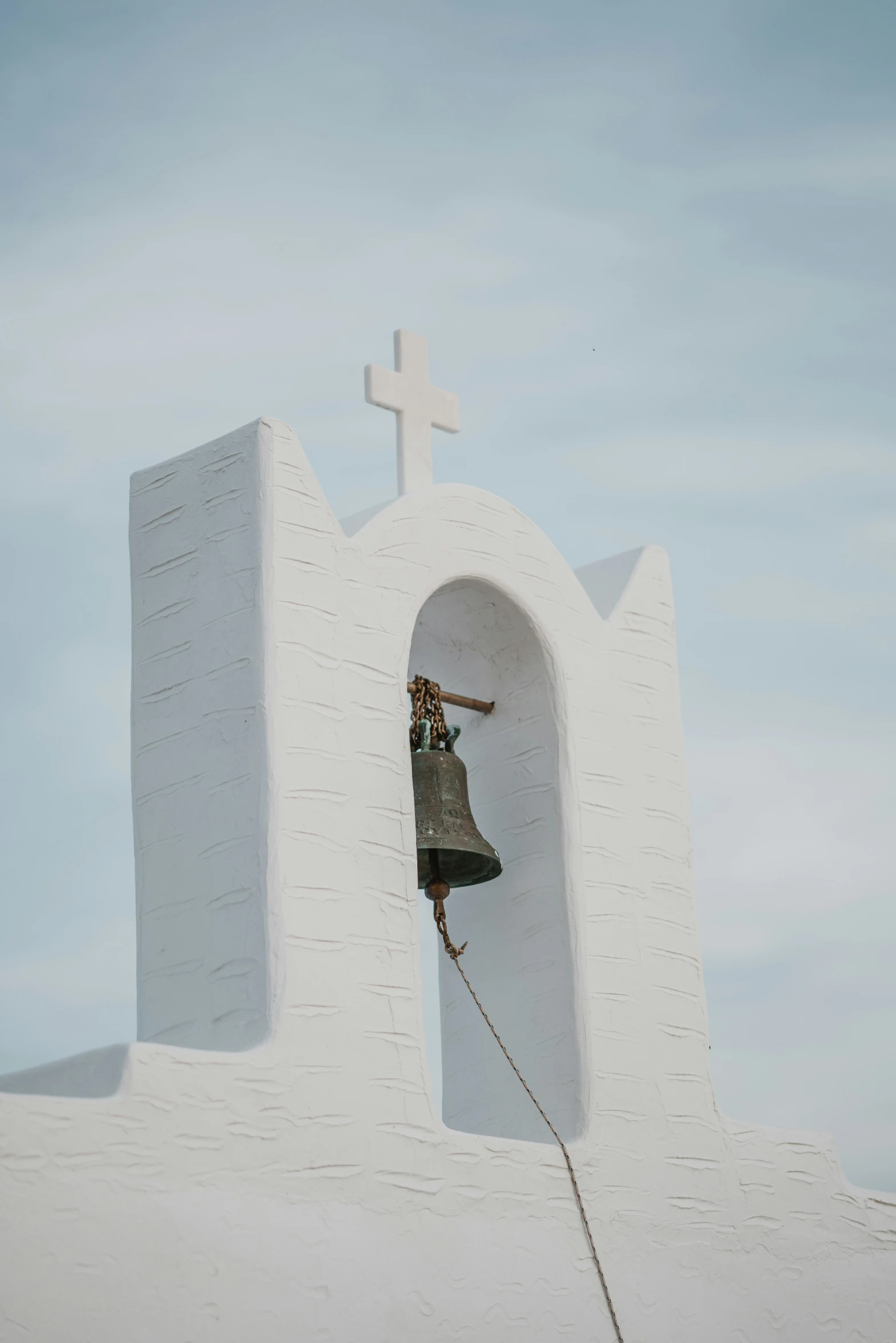 a bell that is hanging from the side of a building