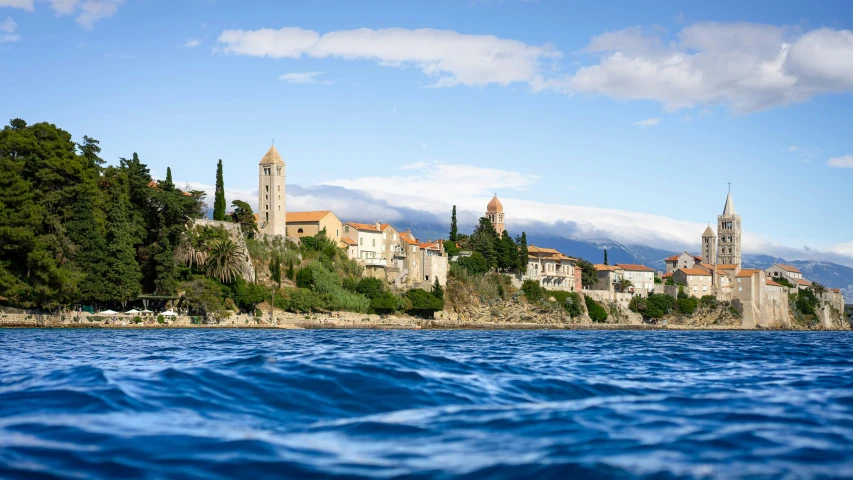 buildings and trees stand above a lake