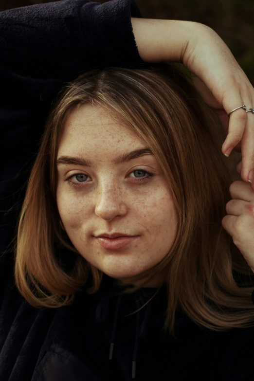 a woman with freckled hair posing for a po