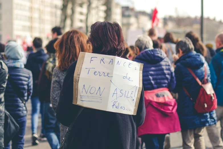 a woman holding a protest sign reading france today