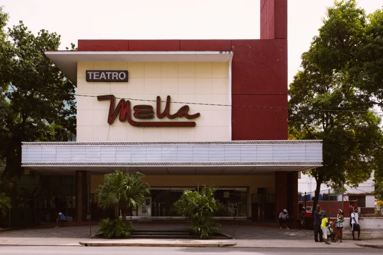 people standing in the driveway of a theater