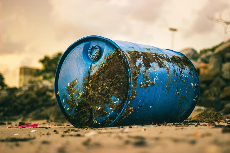 an old blue trash can sitting on the ground