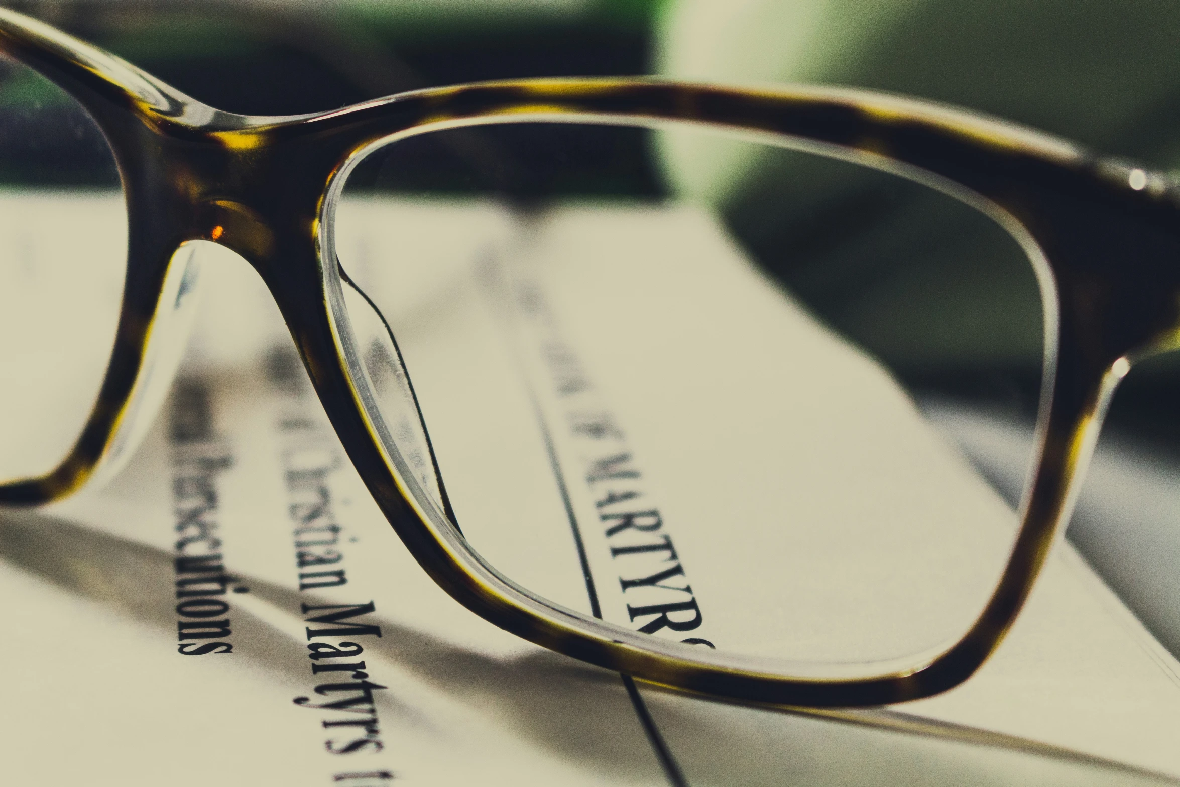 a pair of eyeglasses sitting on top of a piece of paper