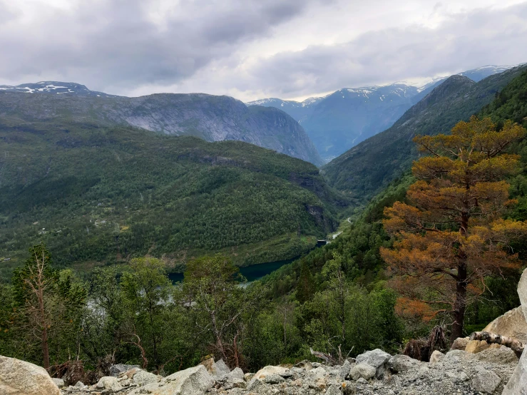 a view of mountains and the trees, with cloudy sky above