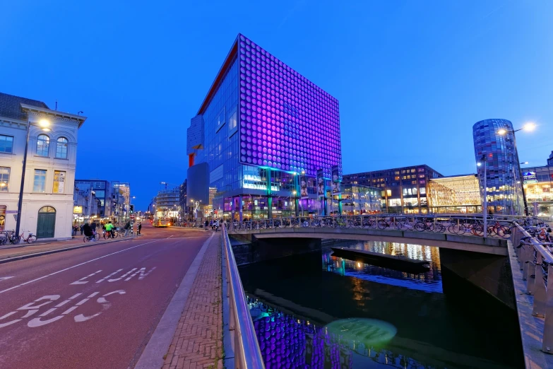 some buildings lights water and a purple light