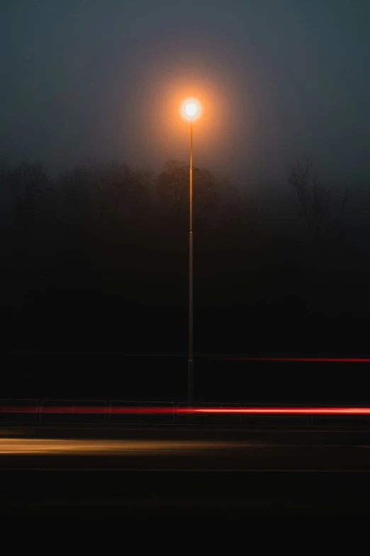 a street light with headlights in the background