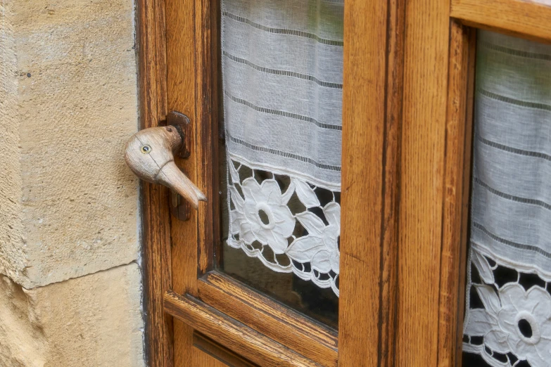 a window with a lace curtain covering is open