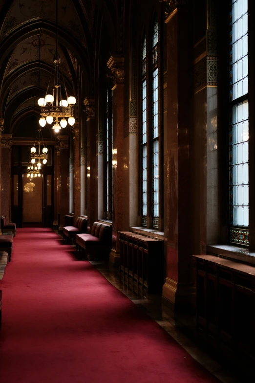 the ceiling is lined with large windows and lit by two chandeliers