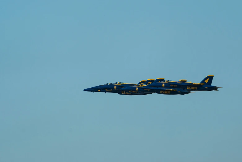 the two jets are flying in formation in a clear blue sky