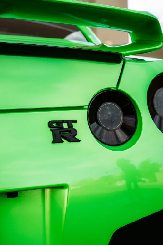 the rear of a green car with black and white stripes