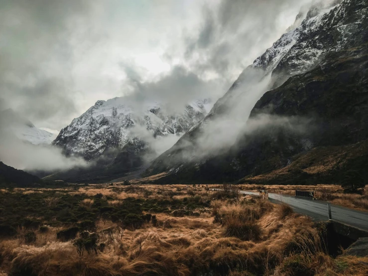 fog shruffed mountains stand tall behind a freeway