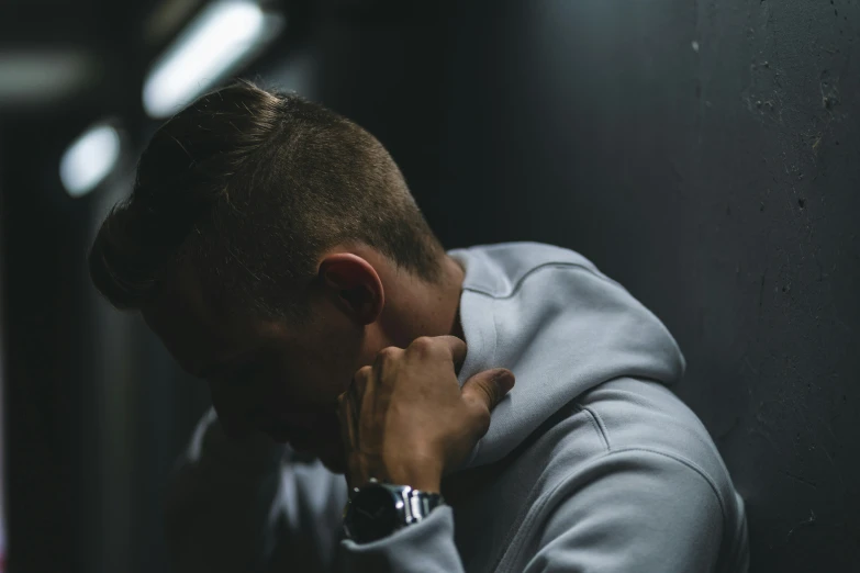 a man is covering his face with his hands