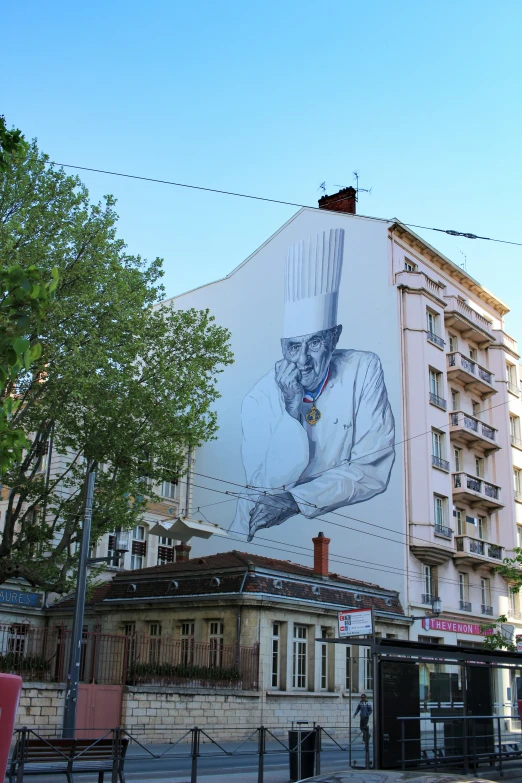 a large white building has a giant painting of a person holding a bat on it's side