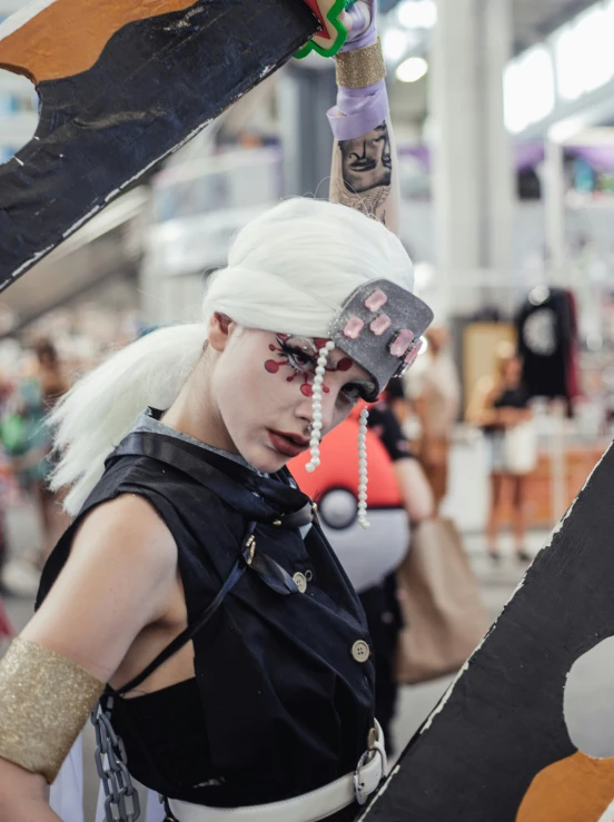 a person in a cosplay and hair accessories standing next to large object