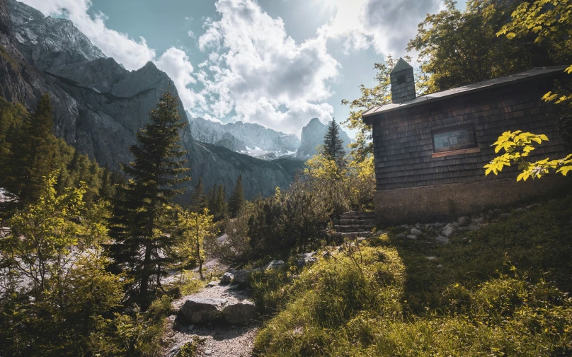 an old cabin in the mountains with a view of the valley