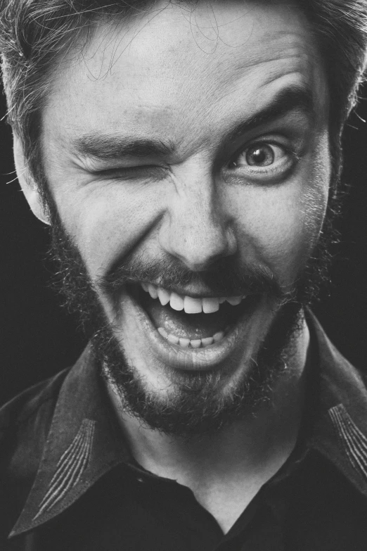 a man with beard and dark shirt smiling