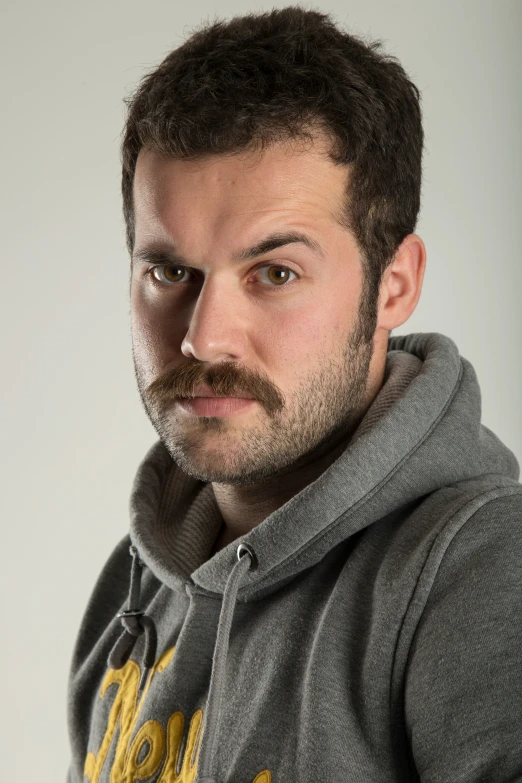 a young man with a goatee mustache and hooded sweatshirt