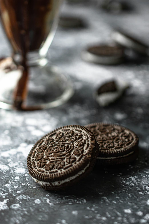 three cookies are sitting on a table next to a glass of drink