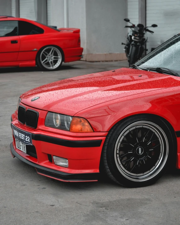 red car parked in a garage with two bikes