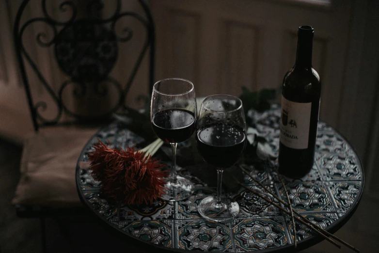 three glasses and a bottle on a table