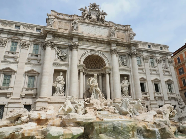 an ornate building with statues and fountains around it