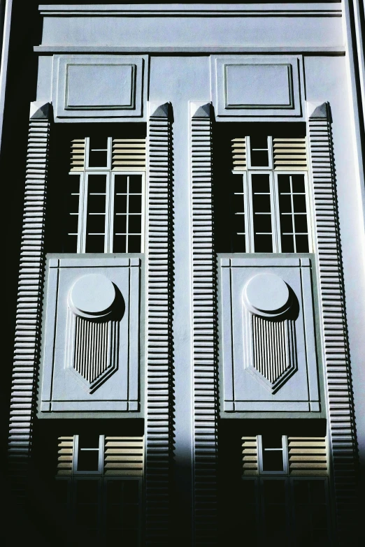 a tall building with three windows and designs