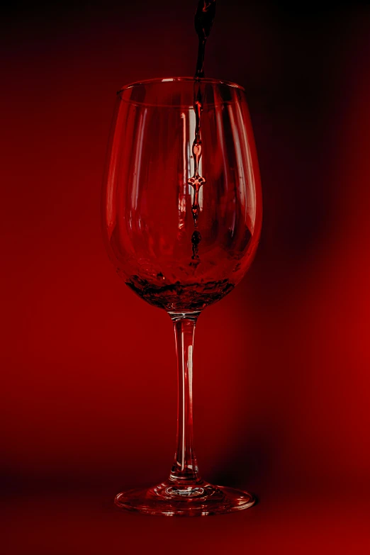 a wine glass that is half filled with wine