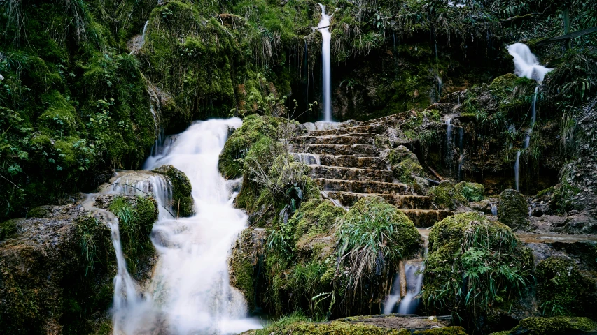 several waterfalls surrounded by lush green trees