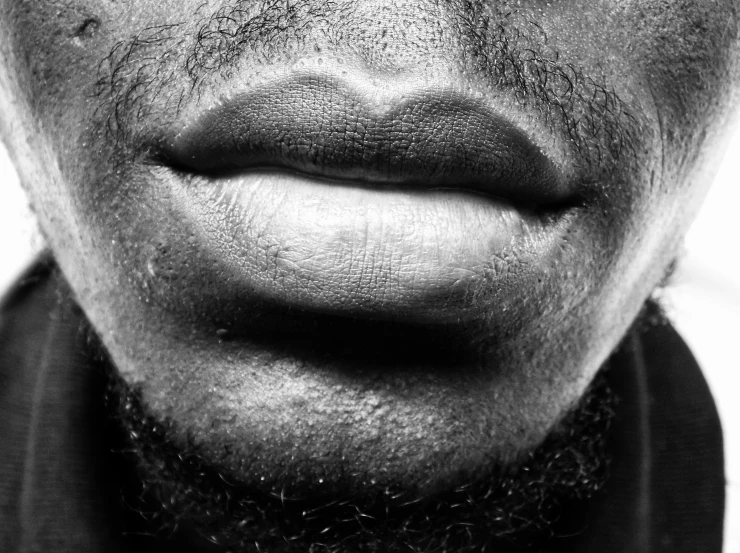 a black and white image of a close up of a man's mouth